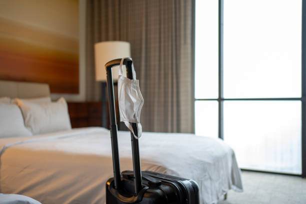 istock Face Mask and Suitcase in the Hotel Room 1317456587