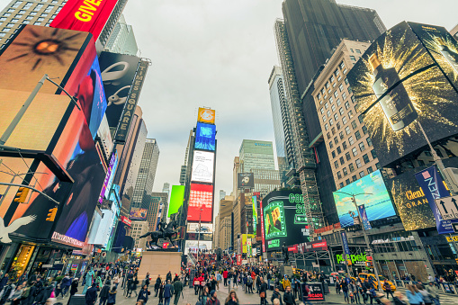 Timesquare Newyork,United States Nov 28 2019:Crowded tourist people,vehicel traffic coummuter and advertising billboards neon displaying advertisement nightlife in Times Square famous landmark ,people lifestyle technology concept
