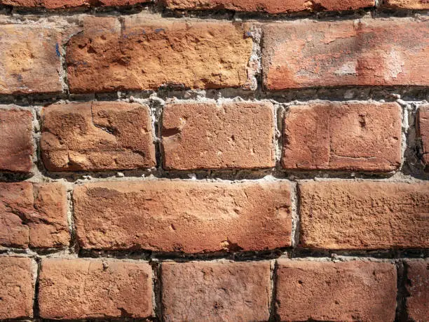 Background of red-brick masonry texture. Pattern of rude 250-years old wall. Close-up