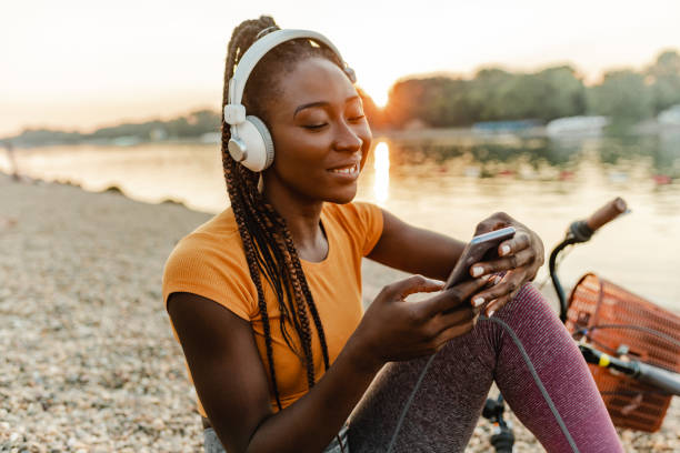 istock African American woman using mobile phone and resting from bicycle ride 1317459007