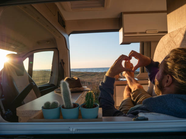 istock Man lying in a van looking at ocean 1317460198