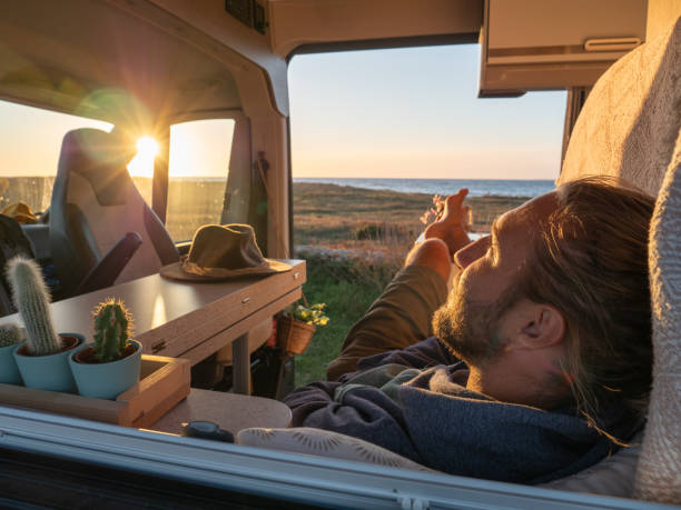 istock Man lying in a van looking at ocean 1317460205