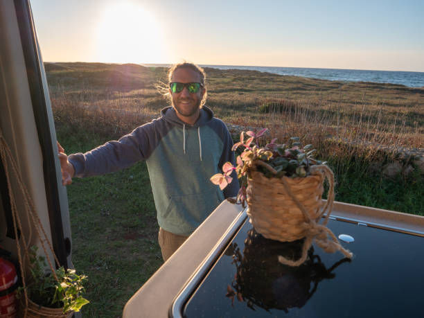 istock Man by the beach walks back to his van, road trip concept 1317460254