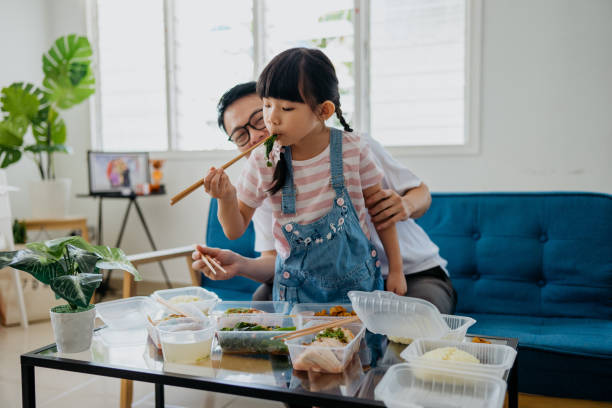 Asian man having take out food with his daughter
