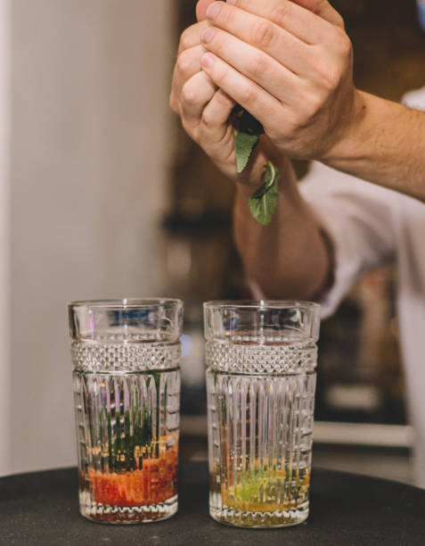 istock Barman making two mojitos with mint leaves, strawberry and aged rum 1317466457