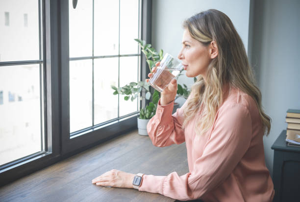 istock attractive middle aged woman in the office ( drinking water) 1317466581