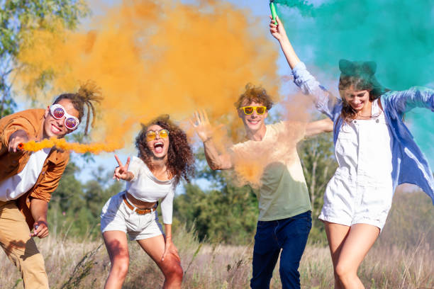 istock Happy friends having fun in the park with multicolored smoke bombs 1317468022