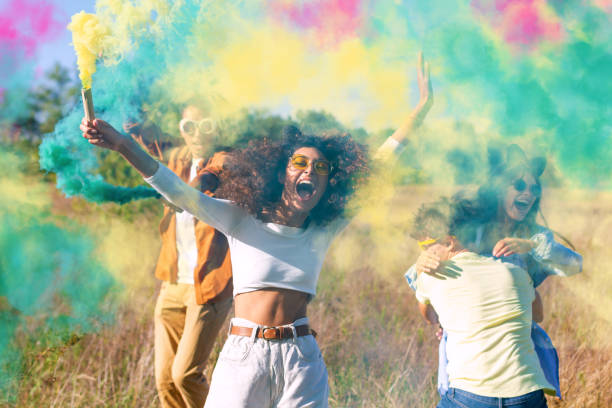 istock Happy friends having fun in the park with multicolored smoke bombs 1317468043