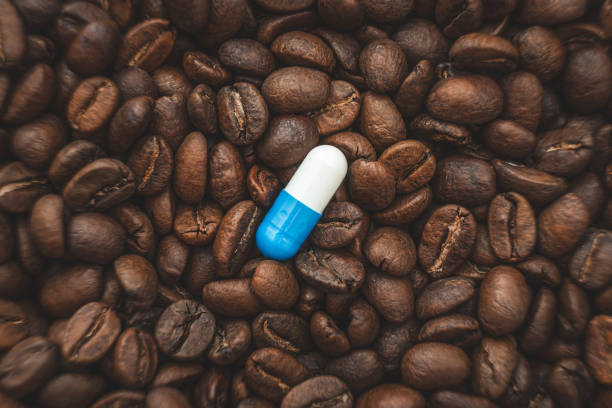 caffeine supplements. pill on the background of coffee beans. caffeine photos stock pictures, royalty-free photos & images