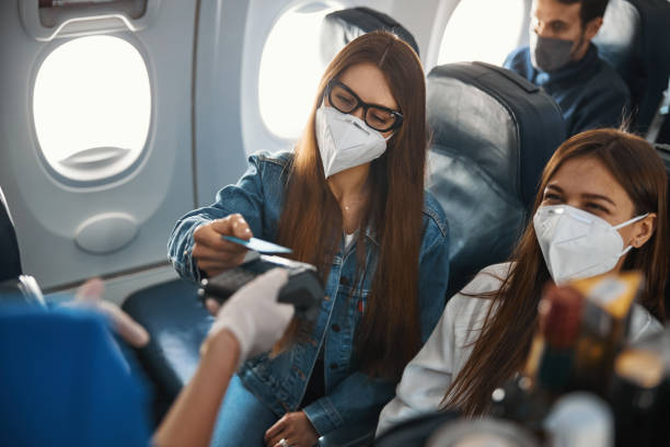 istock Young plane passenger using bank card for payment on terminal 1317469051