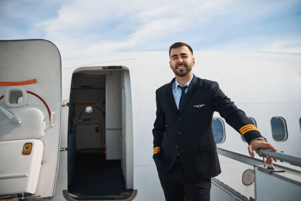 istock Handsome pilot standing on airstairs to plane 1317469147
