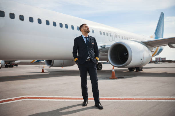 istock Pilot looking far away while standing on runway near plane 1317469165