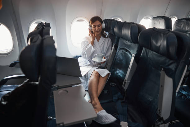 istock Traveller in plane cabin enjoying music with coffee 1317469224