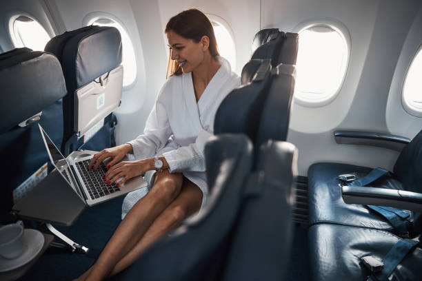 istock Female in dressing gown using laptop on a plane 1317469225