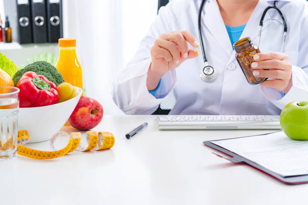 istock Nutritionist holding nutritional supplement capsule 1317471694
