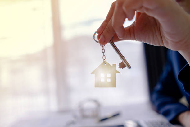 배경 햇빛에 키 하우스를 보여주는 주택 판매자 또는 부동산 부동산. 구입주택의 제공, 부동산 컨셉의 임대. - key sold buying contract 뉴스 사진 이미지