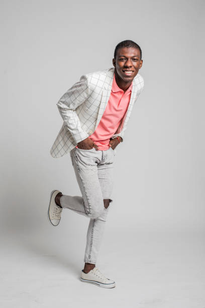 istock Fashionable young man laughs, dances and moves on grey backdrop. 1317473759