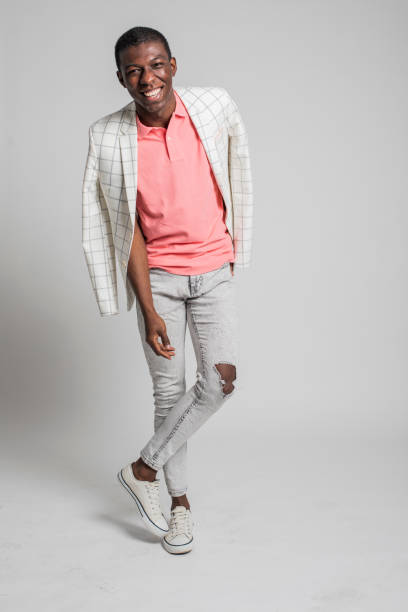 istock Fashionable young man laughs, dances and moves on grey backdrop. 1317474330