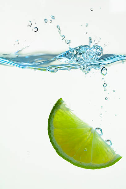 istock A slice of lime is falling into the water. 1317476317