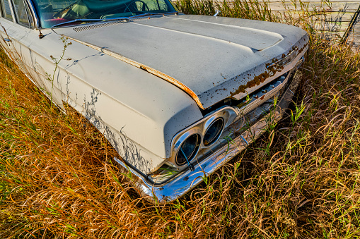 Old car wreck fit for scrap on a meadow