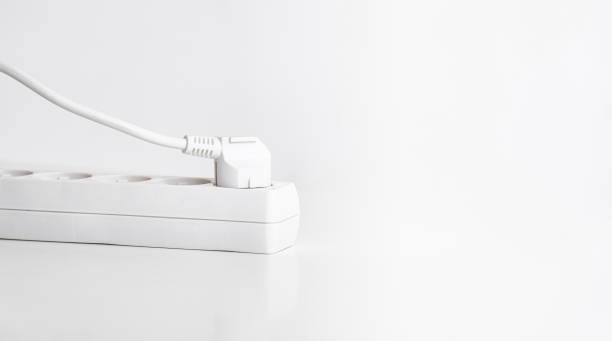 istock White power strip with plug on table and white background. 1317477863