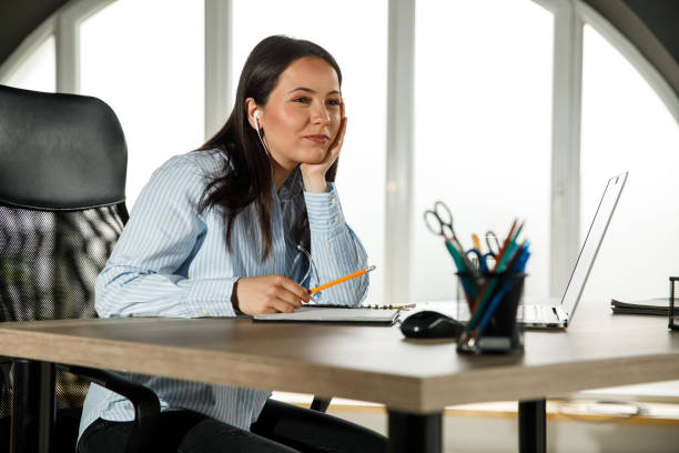 istock Smiling young woman contemplating while attending web conference 1317481629