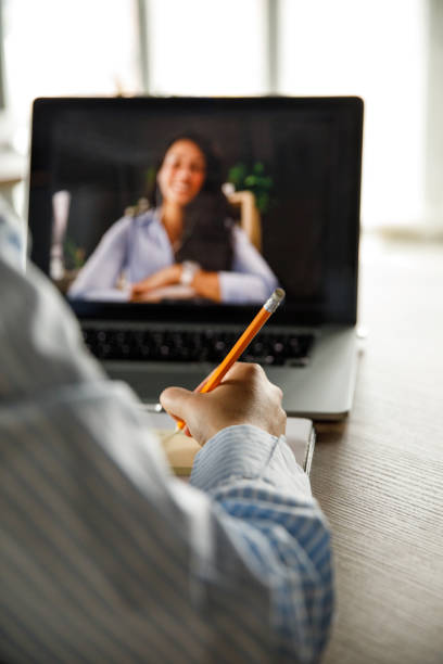 istock Businesswoman writing notes during video conference with a coworker 1317482419