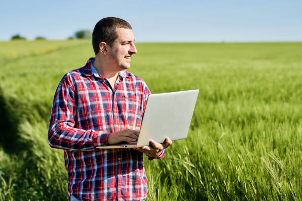 istock Young farmer examining his agricultural field and using laptop 1317486966