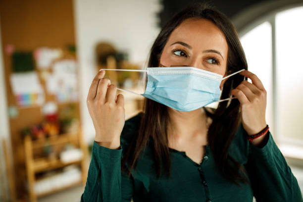 istock Responsible young woman putting a protective face mask 1317487300