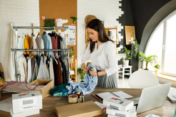 istock Young woman folding a shirt to pack and ship to a customer 1317488045