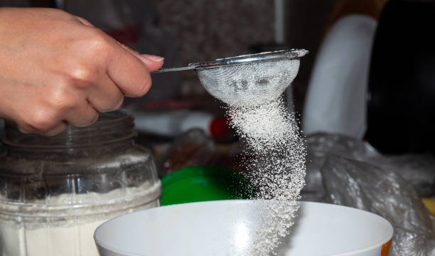 istock A hand holds a small metal sieve, sifting white blemish into a bowl. Selective focus. 1317490120