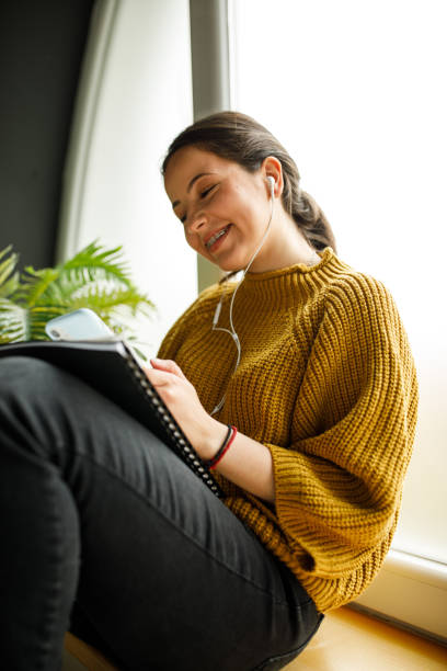 istock Cheerful young woman texting friends while studying 1317491142