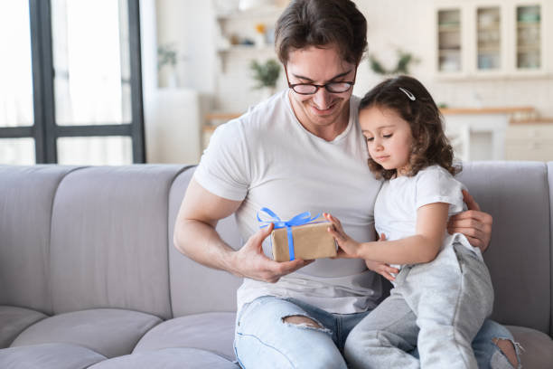 istock Loving cute little kid small daughter giving her daddy a present to congratulate with father`s day, birthday. I love you, dad! Family holiday, parenthood, fatherhood 1317493625