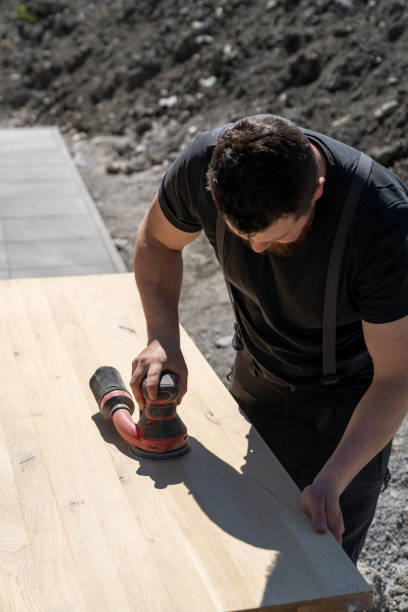istock construction worker using a cordless power sander to sand a massive wooden table top 1317495178