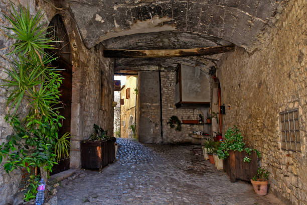 The old town of Sermoneta, Italy. Sermoneta, Italy, 05/10/2021. A narrow street between the old stone walls of a medieval town in the Lazio region. village lazio photography sermoneta stock pictures, royalty-free photos & images