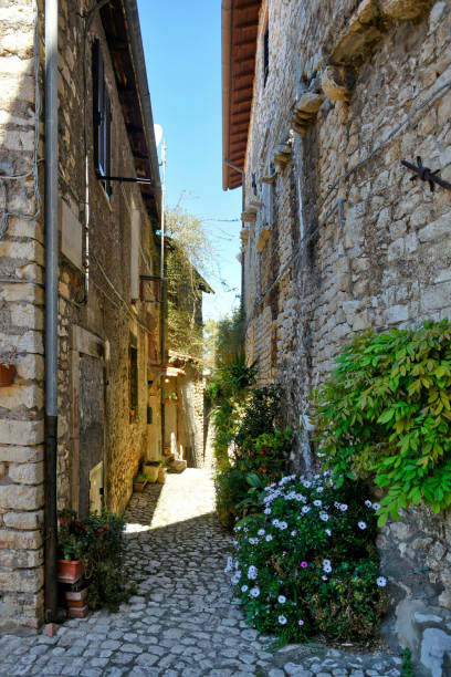 The old town of Sermoneta, Italy. Sermoneta, Italy, 05/10/2021. A narrow street between the old stone walls of a medieval town in the Lazio region. village lazio photography sermoneta stock pictures, royalty-free photos & images