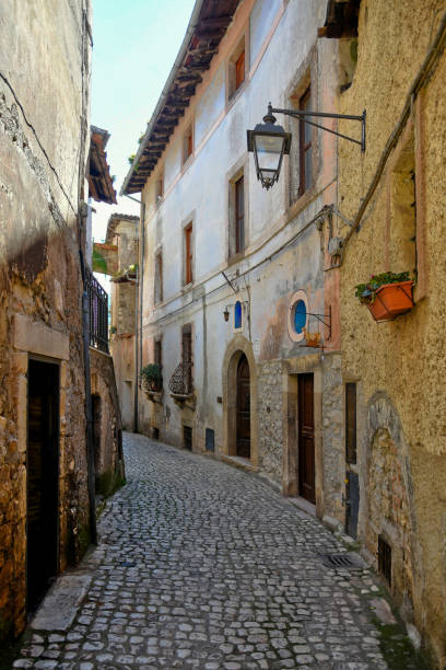 The old town of Sermoneta, Italy. Sermoneta, Italy, 05/10/2021. A narrow street between the old stone walls of a medieval town in the Lazio region. village lazio photography sermoneta stock pictures, royalty-free photos & images