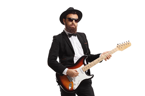 Bearded male guitarist in a suit isolated on white background