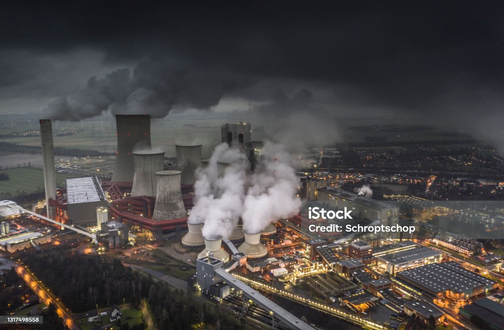 Lignite Power Plant - Aerial View Aerial view of emissions rising from the cooling towers of a lignite fired power station in Germany. Dark clouds at dusk. Greenhouse Gas Stock Photo