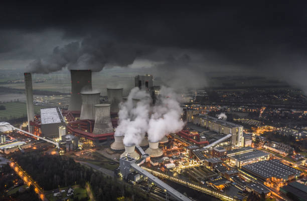 Lignite Power Plant - Aerial View Aerial view of emissions rising from the cooling towers of a lignite fired power station in Germany. Dark clouds at dusk. fumes stock pictures, royalty-free photos & images