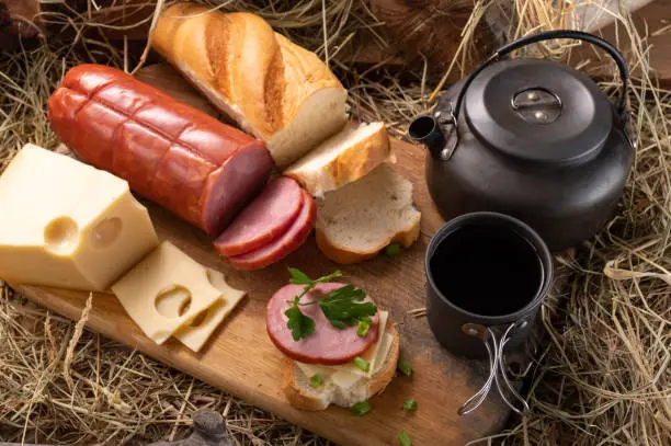 Photo of Lunch in the manger. Lunch in the barn in the hay. Sandwich and tea.