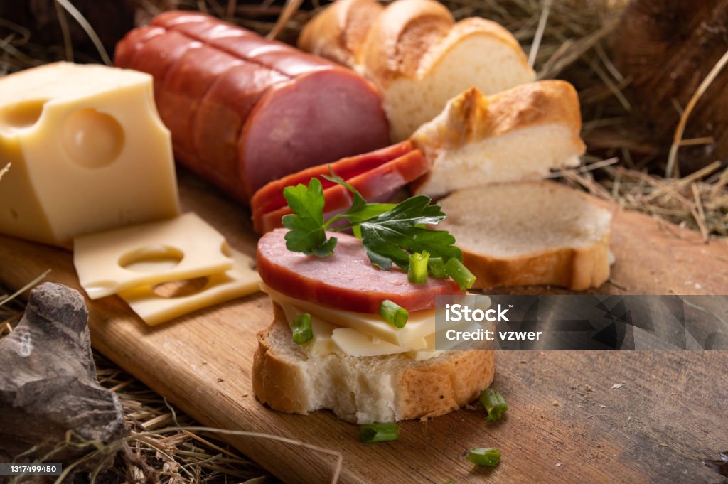 Sausage baguette sandwich. Close-up sandwich. The products lie in the hay. Sausage baguette sandwich. Close-up sandwich. The products lie in the hay. Front view. Airplane Hangar Stock Photo