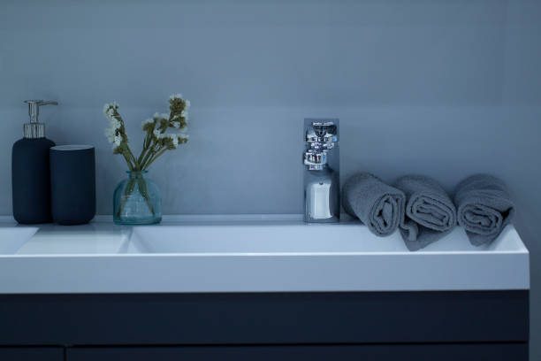 clean modern washstand with clean rolled towels and hygiene items placed on it
