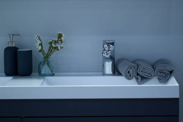 czysta nowoczesna umywalka z czystymi walcowanymi ręcznikami i umieszczonymi na niej elementami higienicznymi - washstand zdjęcia i obrazy z banku zdjęć