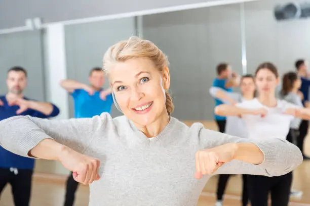 Photo of Middle-aged woman exercising at dance class