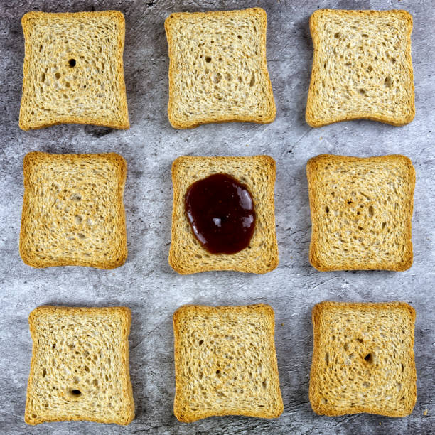 a pattern made of rusks including one in the center different because with jam on top - wheat pasta flour italy imagens e fotografias de stock