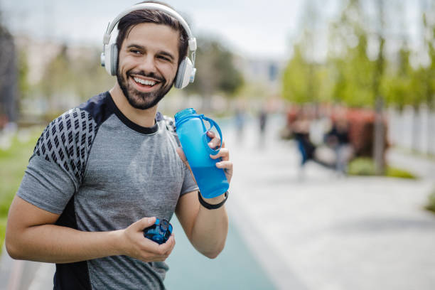 istock Young man in sportswear is drinking water after jogging 1317513334