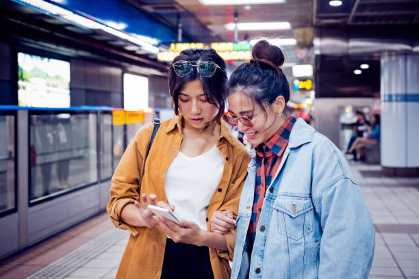 istock Women discussing over phone at subway station 1317513475