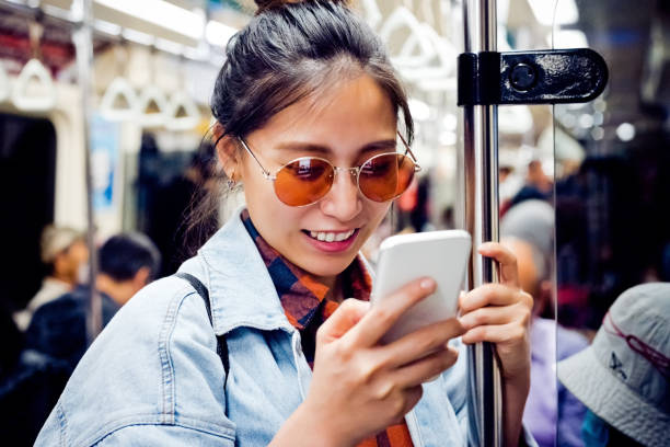 istock Woman using smart phone in subway train 1317514346