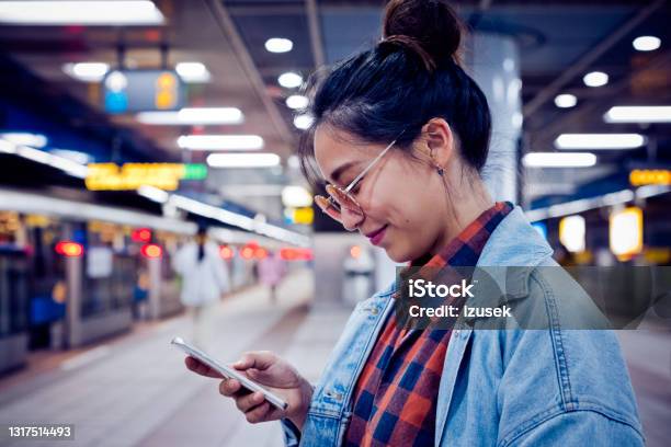 Woman Using Mobile Phone At Subway Station Stock Photo - Download Image Now - Human Face, Illuminated, One Woman Only